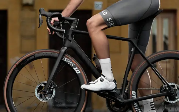 Radfahrer auf einem schwarzen Rennrad, dessen Rahmen aus Carbon gefertigt ist. Das Material Carbon, woraus besteht carbon, ist leicht und stabil.